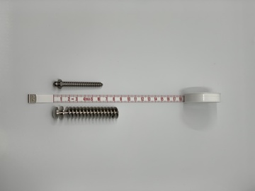 Spirale oder Kondensator für den Inhalator aus Edelstahl im Vergleich mit einer Knochenschraube.